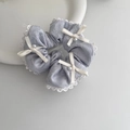 Detalle de coletero de jacquard azul claro con encaje blanco y lazos de perlas finas - Azul