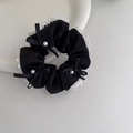 Detalle del coletero negro con bordes de encaje blanco y acentos de lazos de perlas - Negro