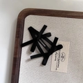 Detail of a black ribbon bow hair clip with an intricate woven mesh pattern on linen - Black