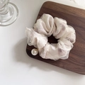 Primer plano de un coletero de malla con estampado floral y un gran colgante de perla - Floral Púrpura