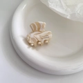 Vista dettagliata della piccola clip per capelli in acetato marmorizzato con scritta elegante - Bianco Latte
