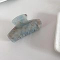 Detail van een glitter acetaat haarklem met blauwe en bruine marmeren textuur - Blauw