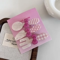 Nahaufnahme von Haarspangen im Besteck-Design mit rosa Schleifen auf Handmade-Karte - Perlmuttweiß