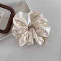 Dettaglio dell'elastico in raso champagne con piccoli fiocchi e trama setosa - Bianco Sporco