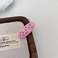 Close-up of pink oval hair clip with colorful dots on linen background for girls - Pink Oval Hair Clip