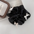 Elegant ballet style black satin scrunchie with cream white bows on ceramic tray - Black
