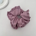 Dettaglio di un elastico per capelli in raso rosa antico con balze e finitura setosa - Rosa