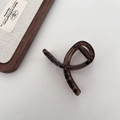 Detail of elegant dark brown tortoiseshell hair claw clip with smooth glossy finish - Small Cross Style / Dark Amber Brown
