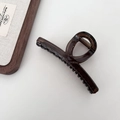 Dark brown translucent shark hair claw clip in a minimalist twisted ring design on white - Hanger Style / Dark Amber Brown