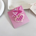 Détail de mignonnes barrettes chat rose et coeur avec texte sur support papier - Paire de Chats Roses