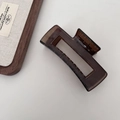 Macro detail of dark brown rectangle hollow claw clip with smooth acrylic texture - Hollow Square Style / Dark Amber Brown