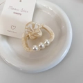 Détail de la pince à cheveux en acétate avec perles et texture effet marbre - Abricot Crème
