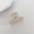 Detalle de una pinza para el cabello en acetato jaspeado beige con texto Barrette - Blanco Crema