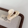 Detail view of pearlescent beige acetate hair claw clip with French lettering - Milky Apricot