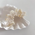 Elegante pinza per capelli in acetato marmorizzato crema su vassoio in ceramica bianca - Beige