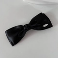 Detalle del lazo de satén negro de doble capa con etiqueta metálica plateada - Negro