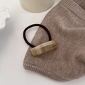 Detail of acetic acid hair tie with France handmade text on marble textured rectangle - Apricot
