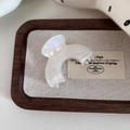 Dettaglio della piccola molletta per capelli in acetato perlato su vassoio in legno rustico - Bianco Sirena