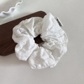 White lace scrunchie with floral eyelet embroidery and branded label on beige background - Large / White