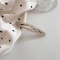 Detail of hollow oval acetate hair clip with grey marble texture on polka dot fabric - Beige Marble