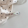 Detail view of oval acetate hair clip with semi-transparent resin and silver metal spring - Iridescent Mermaid