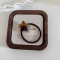 Detail of star-shaped amber pattern hair tie on a decorative beige tray background - 4# Brown Star