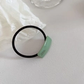 Detailed close-up of a light green geometric acetate resin hair tie with France Handmade text - Green