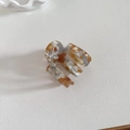 Close-up of amber marble pattern acetate hair claw with minimalist geometric design - Orange
