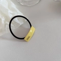Detail of high-elastic hair tie featuring a yellow acetate rectangle with France Handmade text - Yellow