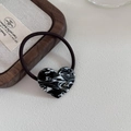 Detailed close-up of marble pattern heart charm with golden France handmade engraving - Black and White Pattern