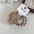Dettaglio di tre elastici per capelli ondulati in motivi zebrati beige e caffè - Beige