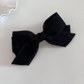 Macro detail of multi-layered black bow hair clip with elegant ruffled edges and texture - Black