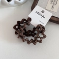 Dettaglio di elastici per capelli a spirale con motivo a zebra marrone su scheda - Caffè Chiaro