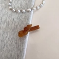 Detail showing amber resin hair clip with France Handmade engraving on grey fabric background - Brown
