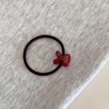Close-up of elastic hair tie with red resin charm featuring gold France Handmade text - Red
