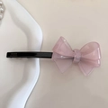Dettaglio del fermaglio per capelli a fiocco in acrilico rosa fatto a mano su un piatto di porcellana - Rosa chiaro