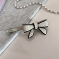 Detail of handmade bow hair clip with France Handmade text on elegant fabric background - White Spring Clip