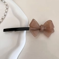 Dettaglio di un fermaglio per capelli a fiocco in acetato marrone con scritta dorata - Marrone chiaro
