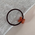 Detail of high-elastic hair tie with orange resin charm and gold France Handmade logo - Orange