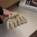 Gros plan sur la grande pince à cheveux beige mat montrant le design courbé et le ressort - Khaki