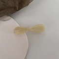 Macro shot of cream bow hair clip with marble texture on minimalist background - Beige