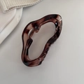 Detailed macro view of large amber tortoiseshell hair claw clip with wavy design - Amber