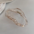 Détail d'une pince à cheveux champagne fluide avec ressort en métal doré - Transparent