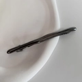 Detail of gunmetal spring hair clip with organic branch texture on a white plate - Gunmetal