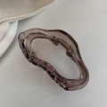 Detailed view of brown wavy liquid-line hair claw clip on soft knit texture background - Light Gray