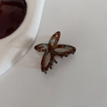 Detail of tortoise shell acetate butterfly hair claw clip on white textured background - Glazed Glass