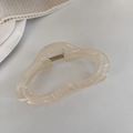 Vue détaillée d'une pince à cheveux ondulée crème avec une texture en résine minimaliste - Litchi Gelée