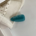 Detail of blue marble water ripple acetate hair clip with gold logo on knit fabric - Blue