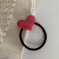 Close-up of a pink marbled resin heart pendant on a black elastic hair tie for women - Rose Red