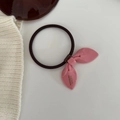 Detailaufnahme eines rosa hochelastischen Haargummis mit goldener Beschriftung - Rosa